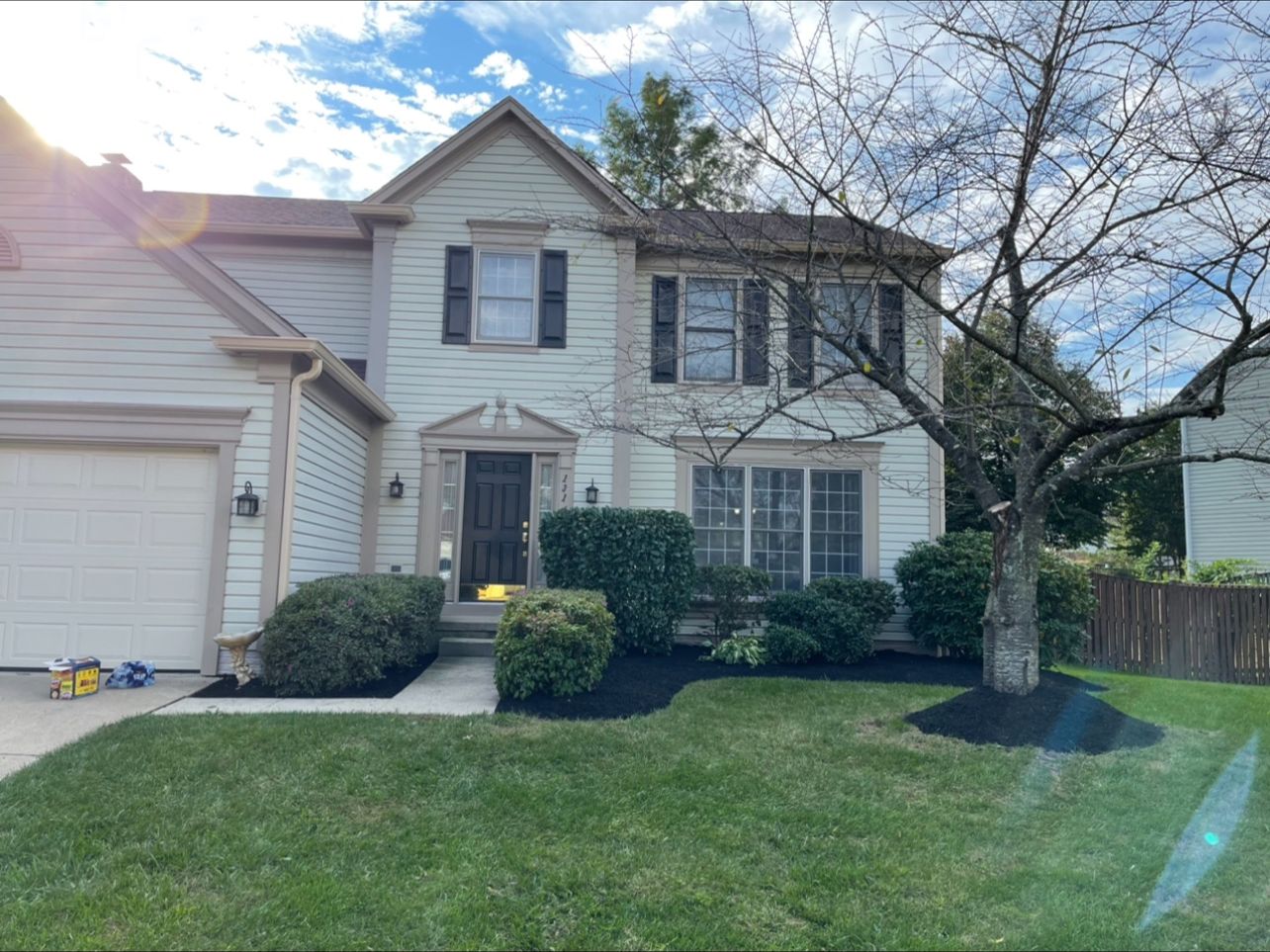 The same home after shrub pruning, bed edging, and fresh mulch