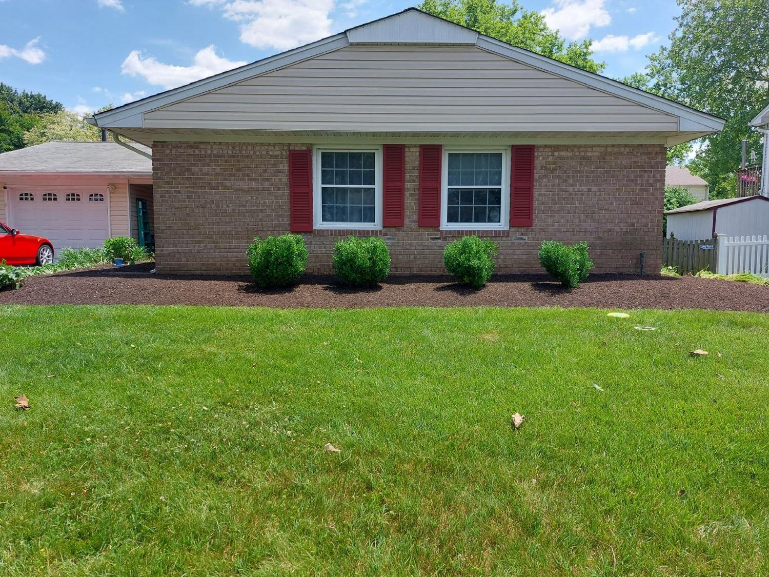Healthy irrigated lawn and fresh mulch beds on a brick ranch