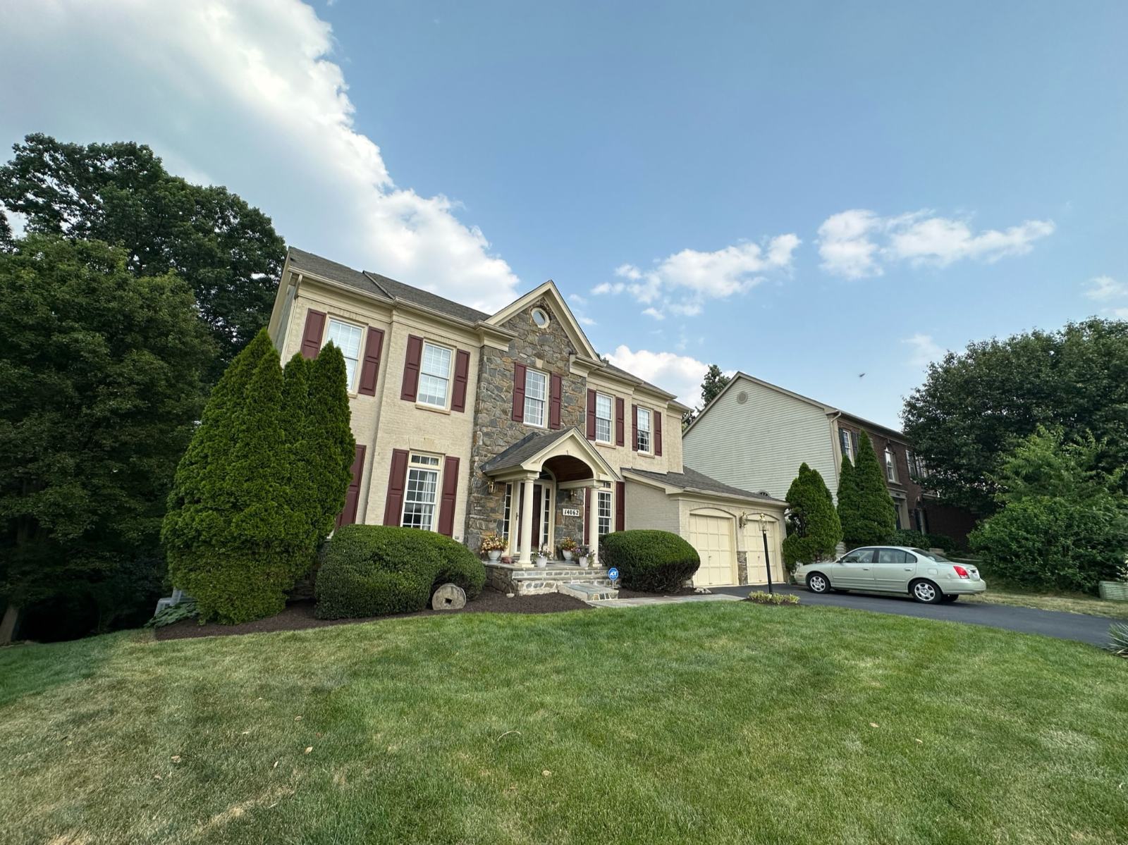 Mature landscape and lawn care at a stone-front colonial