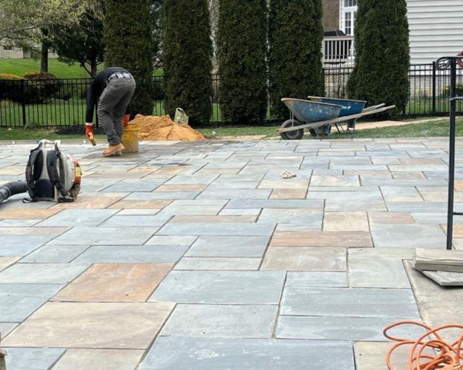 Crew member finishing a cut bluestone patio