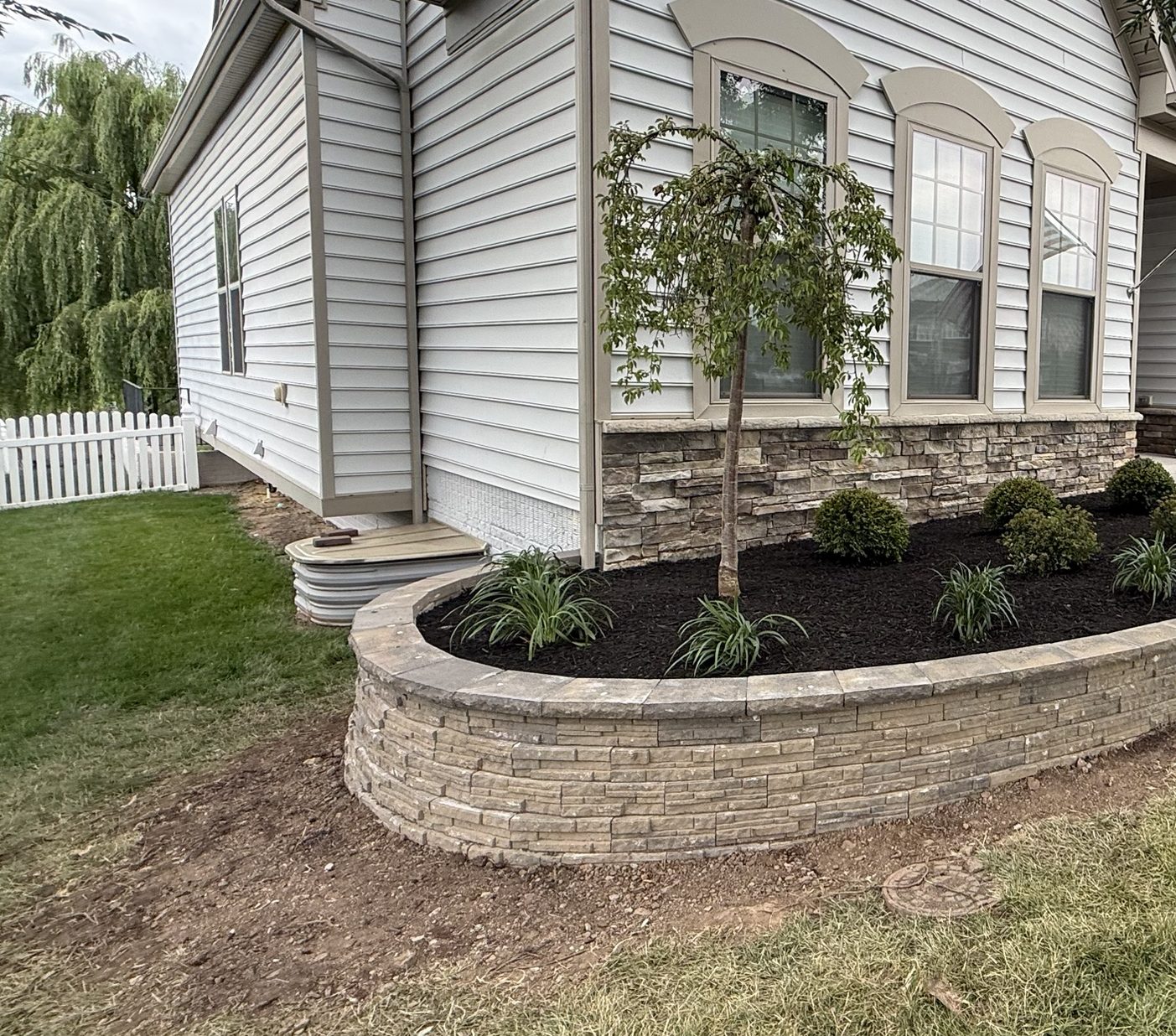 Curved raised bed wall, planted and mulched